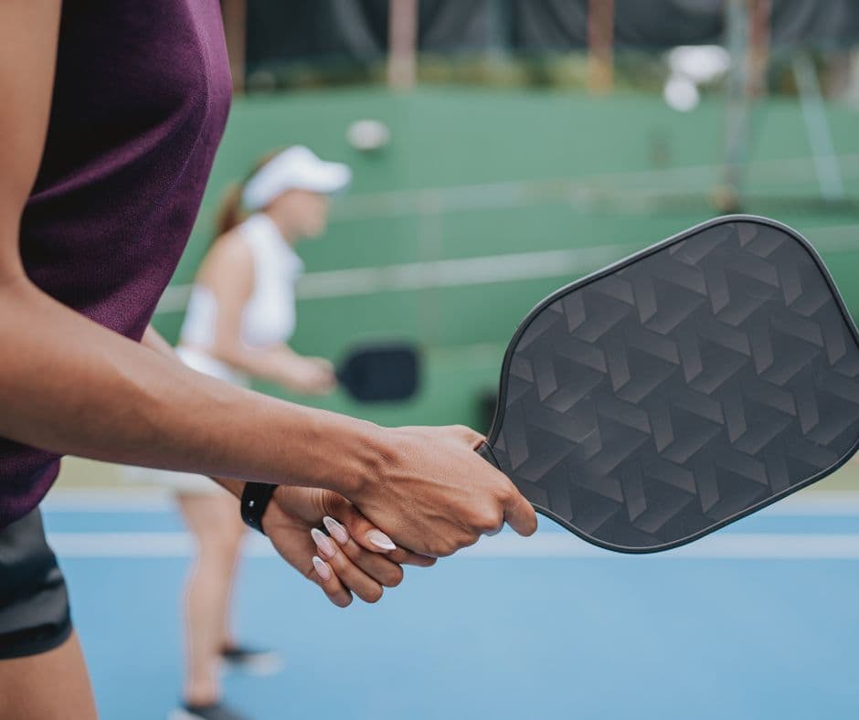 Two pickleball players shaking hands at the net after a game.