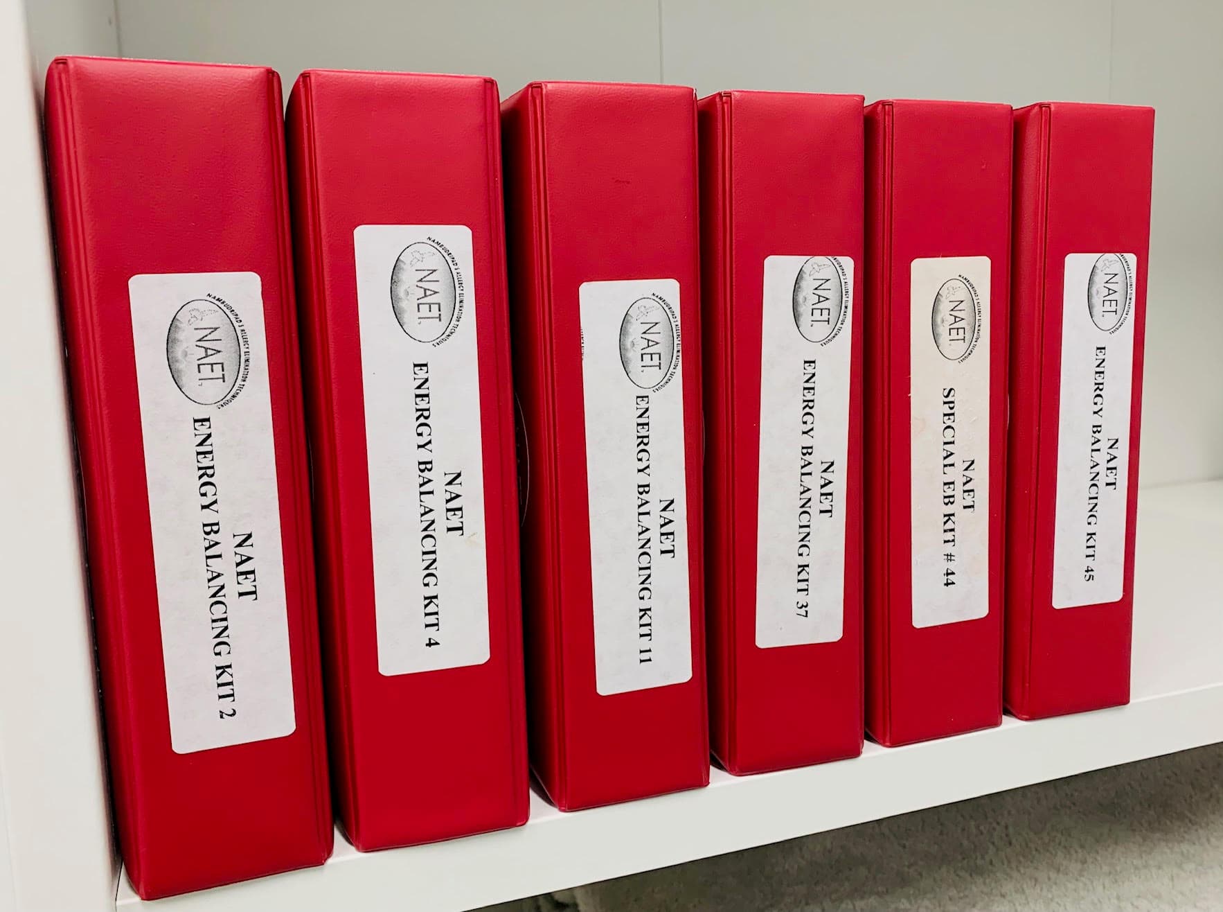 NAET energy balancing kits on a clinic shelf.